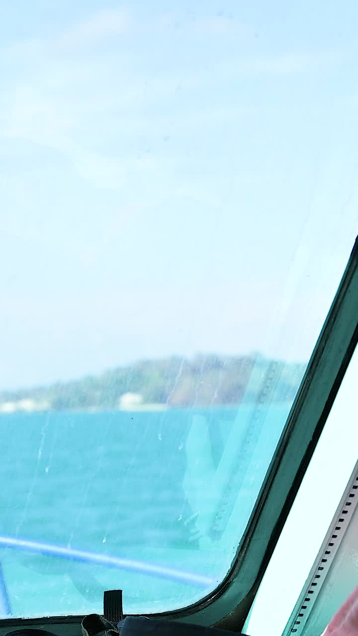 un sereno viaje en barco a través de las aguas turquesas de phuket, capturado desde una vista de ventana, mostrando paisajes marinos tranquilos e islas lejanas