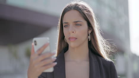 mujer molesta usando un teléfono inteligente en la calle