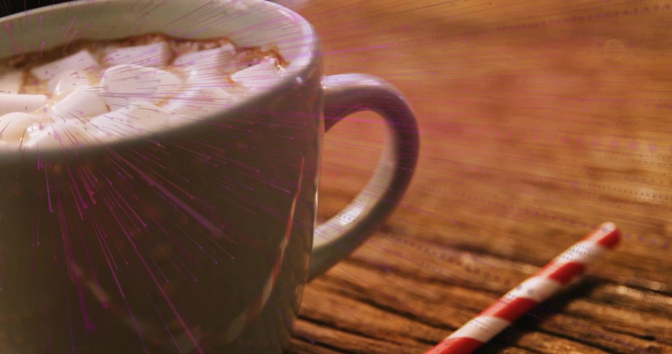 Luce viola che si diffonde sul tavolo vicino a una cannuccia, con marshmallow che iniziano a salire per raggiungere il bordo di una tazza di ceramica.