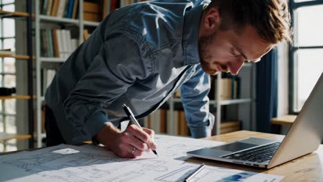 hombre trabajando en planos de ingeniería