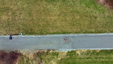 slow motion top down aerial of woman running on paved trail and into tunnel