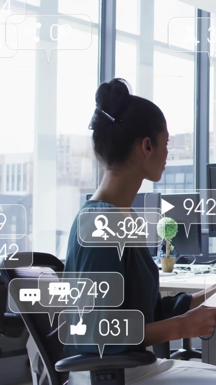 Vertical video: Woman at desk with tablet, new social alerts floating over desk showing data