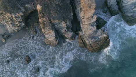 aerial cenital drone shot of waves and rock formations in zicatela beach in the morning, puerto escondido, oaxaca