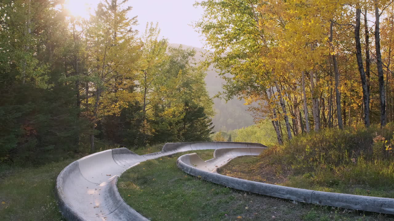 tobogán de montaña alpina al atardecer con colores otoñales
