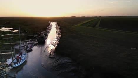 Barcos-De-Vela-Atracados-En-El-Estuario-Con-La-Noche-Con-Luz-Dorada