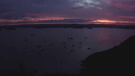 Aerial-of-sail-boats-anchored-as-the-sun-sets-with-majestic-purple-tones-in-the-Bay-of-Islands