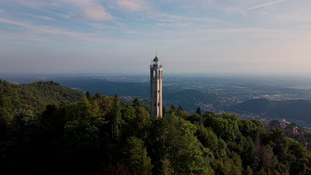 Faro di Brunate - Faro Voltiano - situato su una collina boscosa con vista sulla città in lontananza