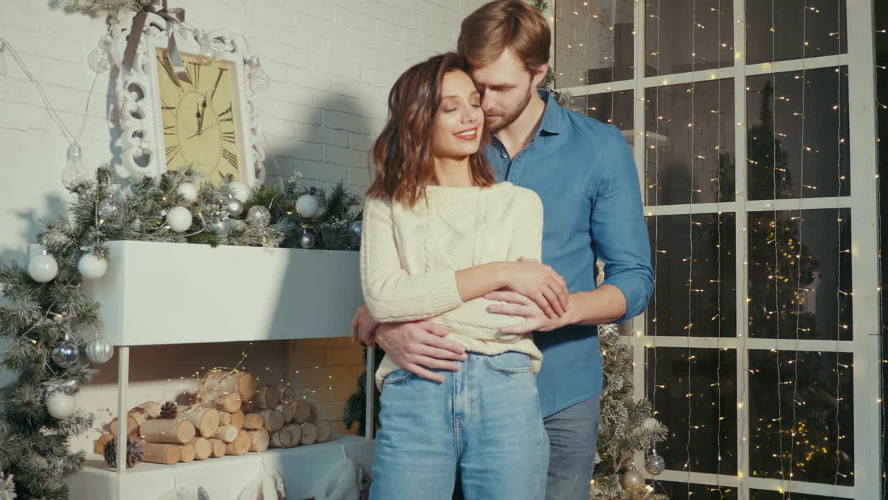 크리스마스 장식 된 인테리어 에서 포옹 하는 부부