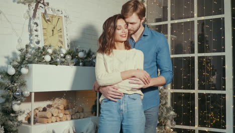 una pareja abrazándose en un interior decorado con navidad
