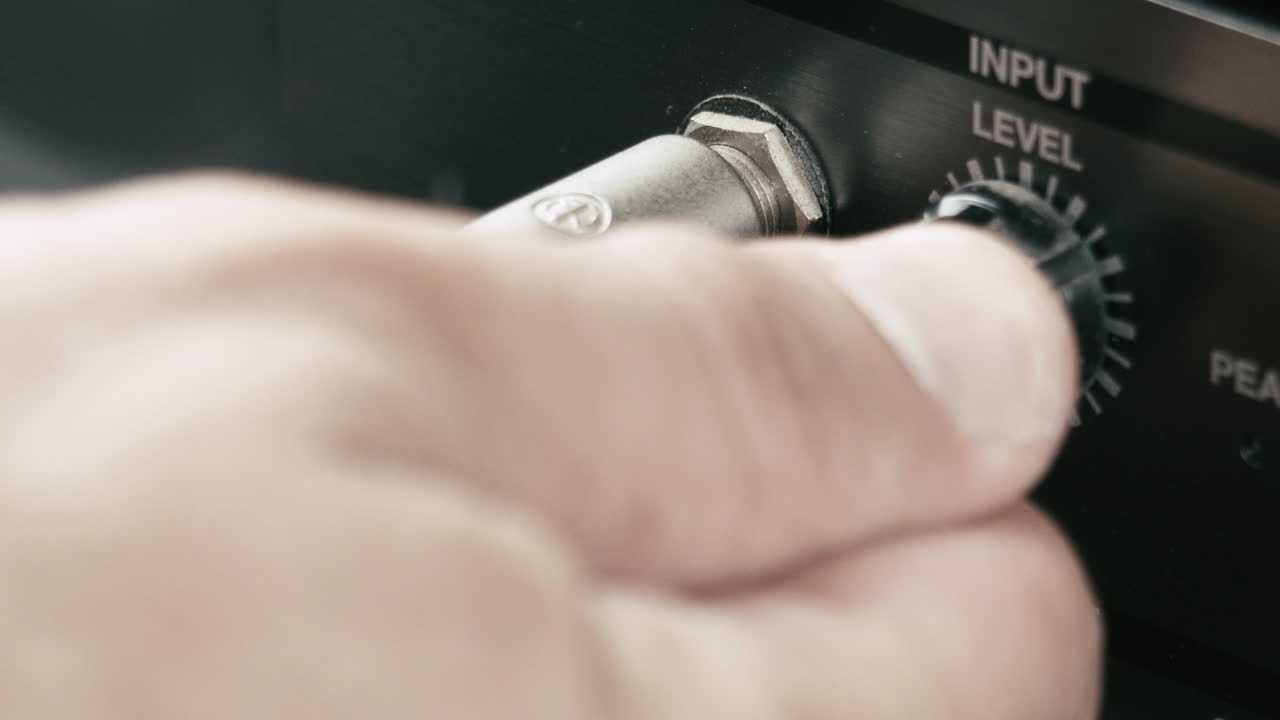 음악가는 잭 케이블을 멀티 효과에 연결하고 입력 레벨을 최대, 매크로 샷으로 설정합니다.