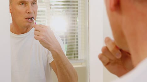 Man-brushing-his-teeth-with-toothbrush-in-bathroom-4k