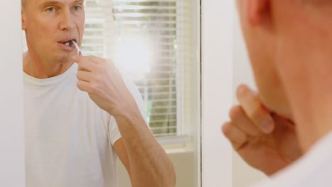 man brushing his teeth with toothbrush in bathroom 4k