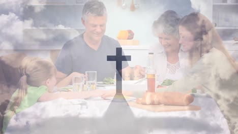 animation of a christian cross casting shadow over a caucasian family praying