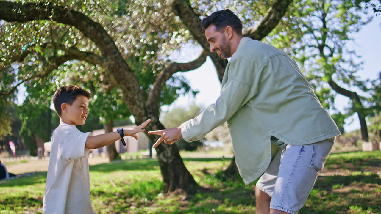 Daddy child playing hands together at summer garden with green grass closeup