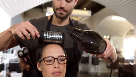 woman getting her hair dried with hair dryer