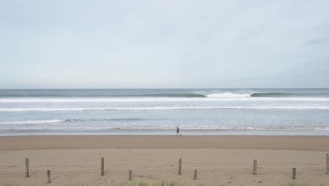 sportsman in active wear jogging on lonely beach