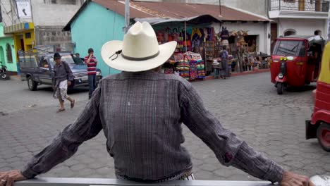 slow motion of mayan man while tuktuks pass in the streets of santiago atitlan guatemala