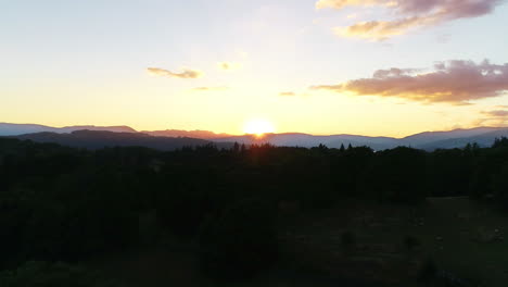 Drone-shot-of-sunset-over-Lake-Windermere-and-the-surrounding-countryside,-Lake-District,-UK