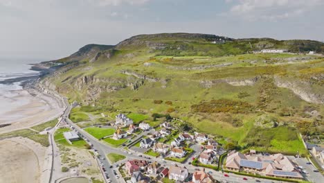 wohngebiet mit riesigen villen an der bucht von conwy mit herrlichem blick auf das meer bei ebbe und die hohen grünen hügel im hintergrund an einem bewölkten tag