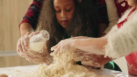 handheld view of family making dough for christmas cookies