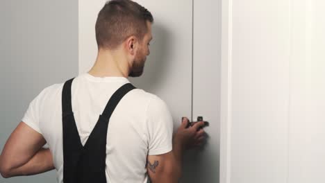 close-up a young man installs a cabinet door