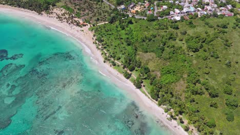 aerial top down of crystal clear caribbean sea water at playa los coquitos. luxury resort hotel area with palm trees in summer. cabrera, dominican republic.