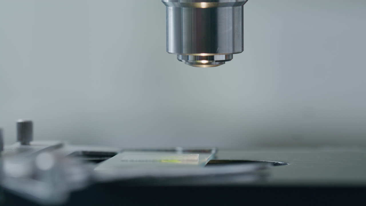 Close-Up of Gloved Hands of Researcher Adjusting Microscope Slide