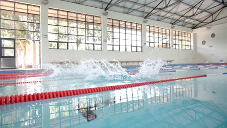 swimming in indoor pool, swimmers creating splashes during practice session, copy space