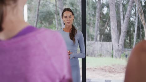 happy female biracial couch explaining in yoga class, slow motion