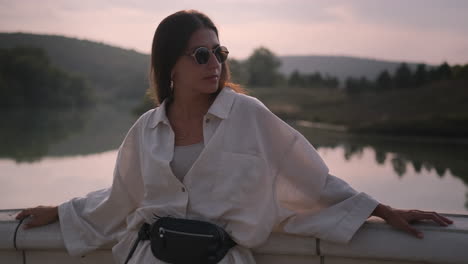 woman relaxing by the lake at sunrise