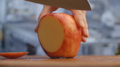 cut a knife on a wooden board closeup red apple in the kitchen. shred