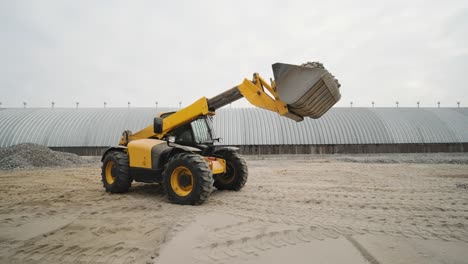 tractor moves rubble to truck. excavator-loader rakes rubble from pile at construction site and loads dump truck. clearing site