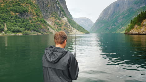 un hombre está pescando en el contexto de los pintorescos fiordos noruegos