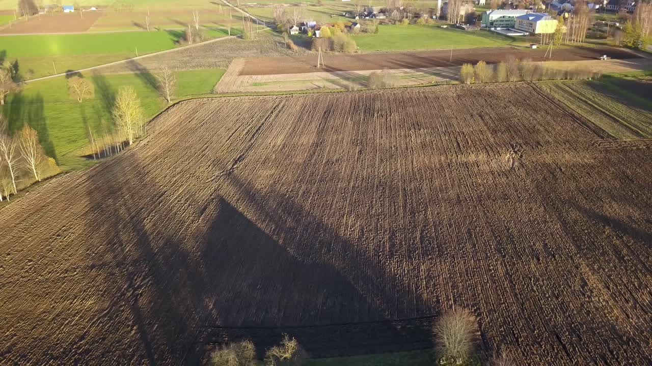 Plowed Dirt Field on Farming Land by Farm House