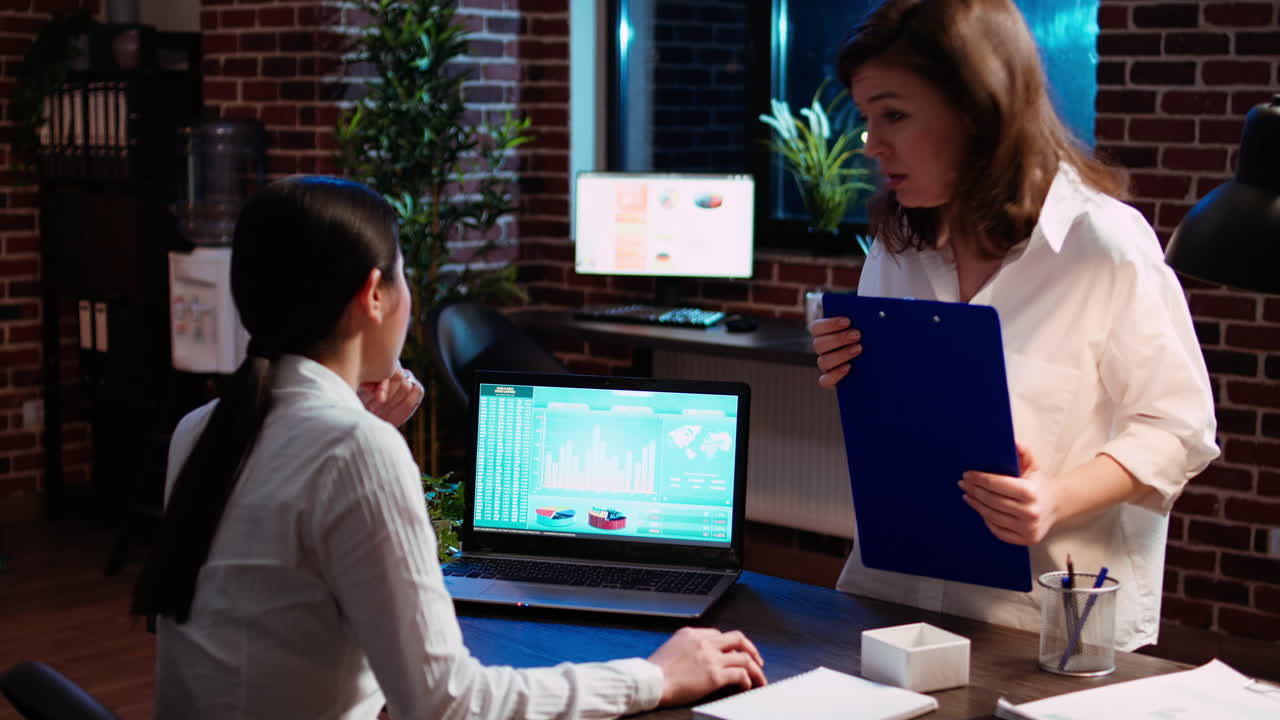 contador de la compañía y compañero de trabajo analizando gráficos de datos financieros