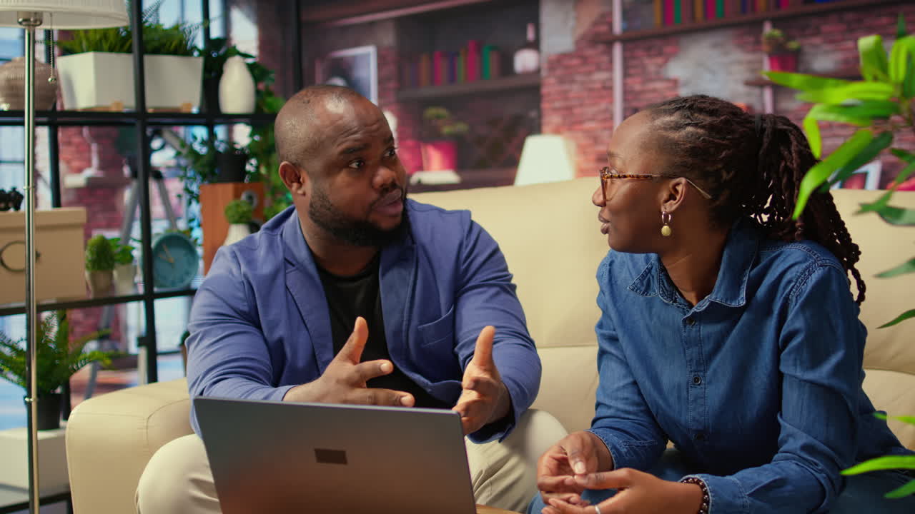 African american young freelancers on couch sharing a business idea