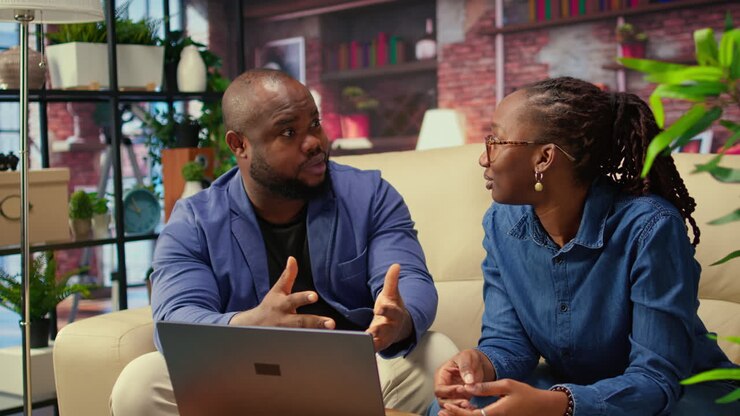 African american young freelancers on couch sharing a business idea