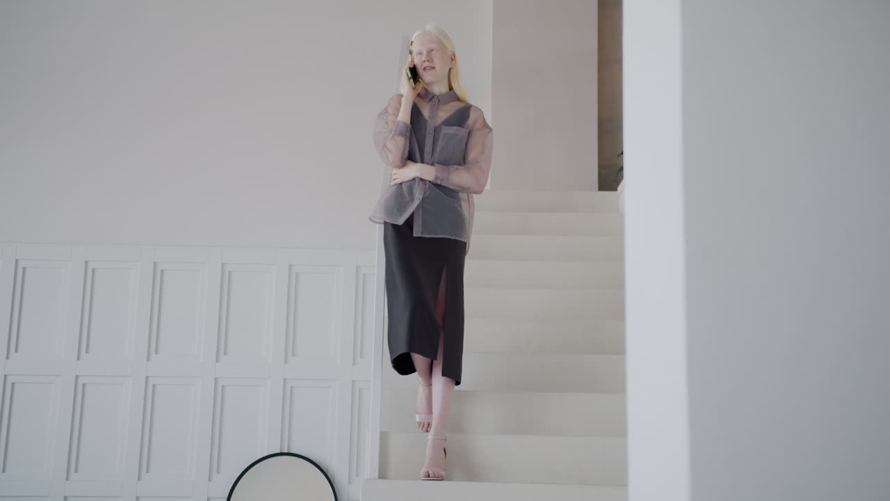 Woman Talking on Phone While Walking Upstairs