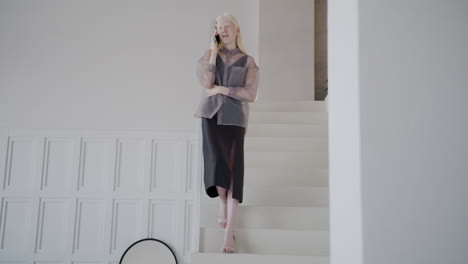 woman talking on phone while walking upstairs