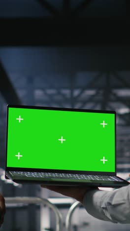 vertical video army tech specialist in data center and coworkers using green screen laptop