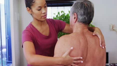 physiotherapist giving shoulder massage to a senior man 4k