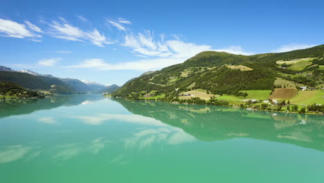 Beautiful-bright-green-hills-and-mountains-by-the-lake-in-Norway--Wide-pan