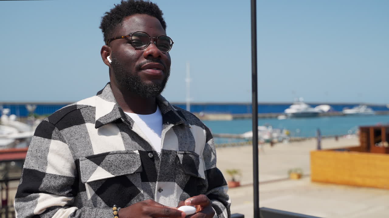 해변에 헤드폰을 들고 있는 남자