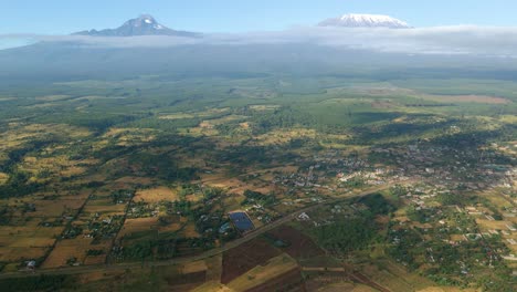 aerial view cloud shadows moving over fields on the countryside of kenya, kilimanjaro mountain background - tracking, drone shot