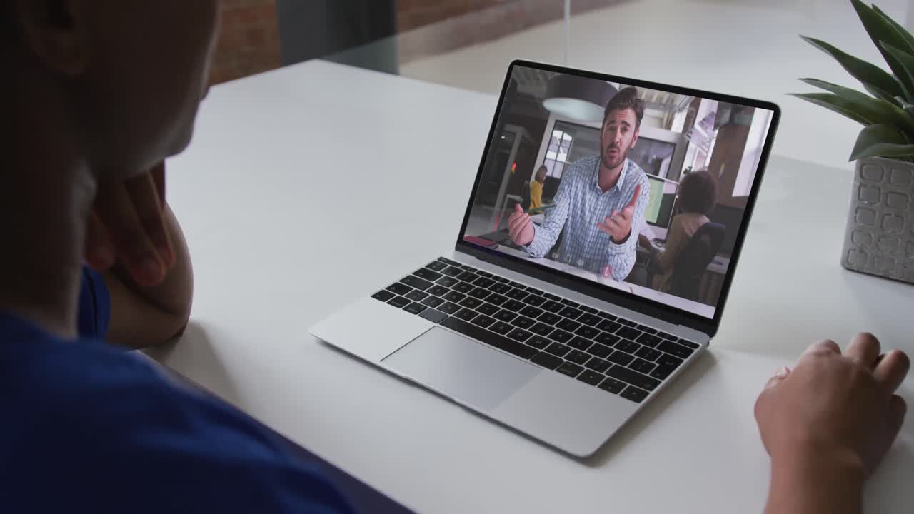 Mid section of african american woman having a video call on laptop with male colleague at office