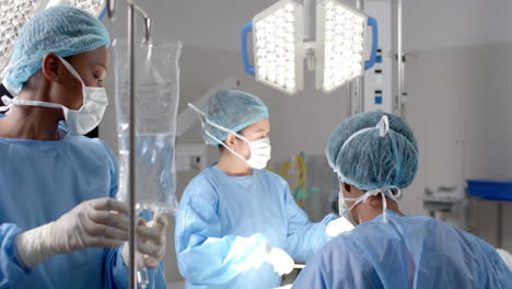 Diverse-female-surgeons-operating-on-patient-in-operating-theatre,-slow-motion