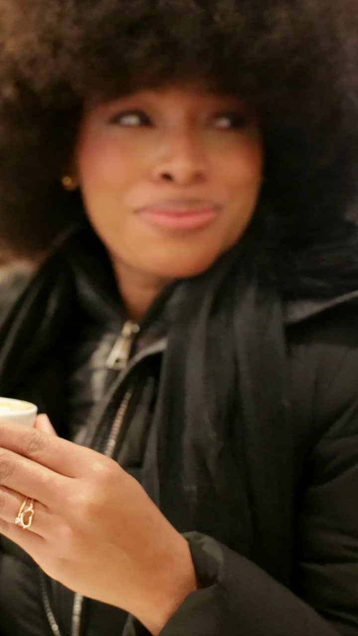 Donna con taglio afro che beve caffè