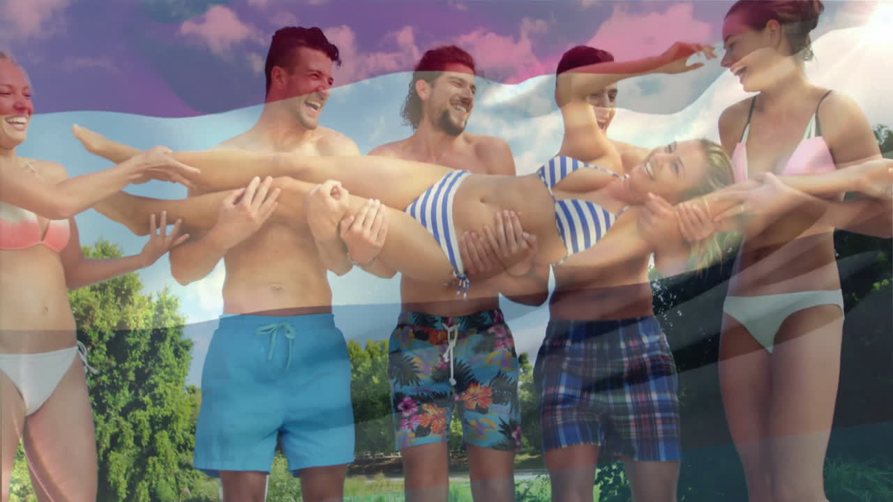 Lifting woman outdoors, group of friends in swimwear celebrating with animation