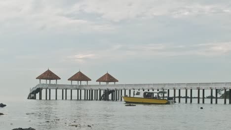 static video of an yellow boat sailing through polluted water with a bridge in the background