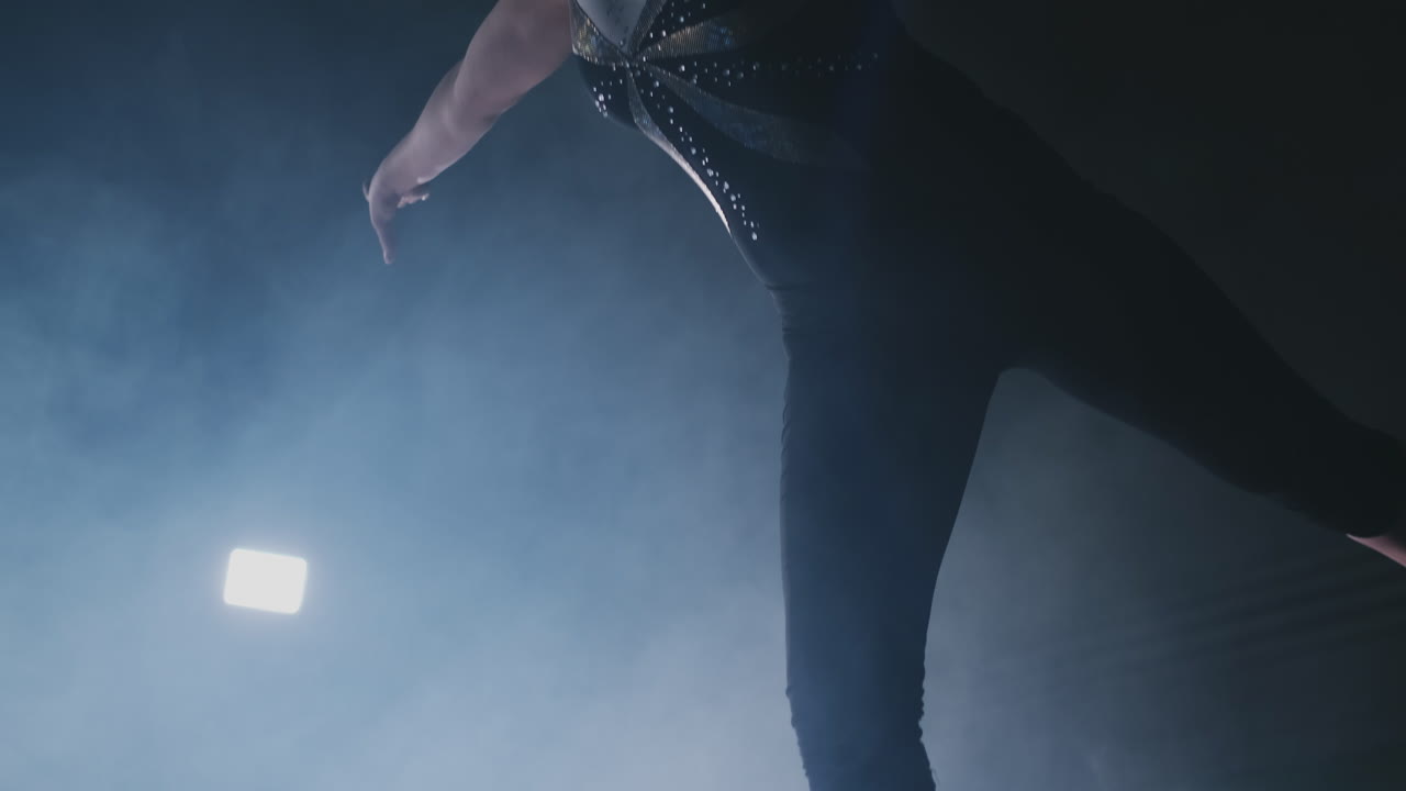 en cámara lenta en el humo, una atleta de pie con los brazos levantados después de realizar ejercicios. gesto de bienvenida con las manos.